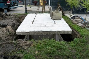 Concrete septic tank with a capacity of 10 m3 located in the garden next to the house.